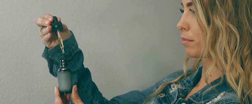 Frau mit THC Öl in der Pipette