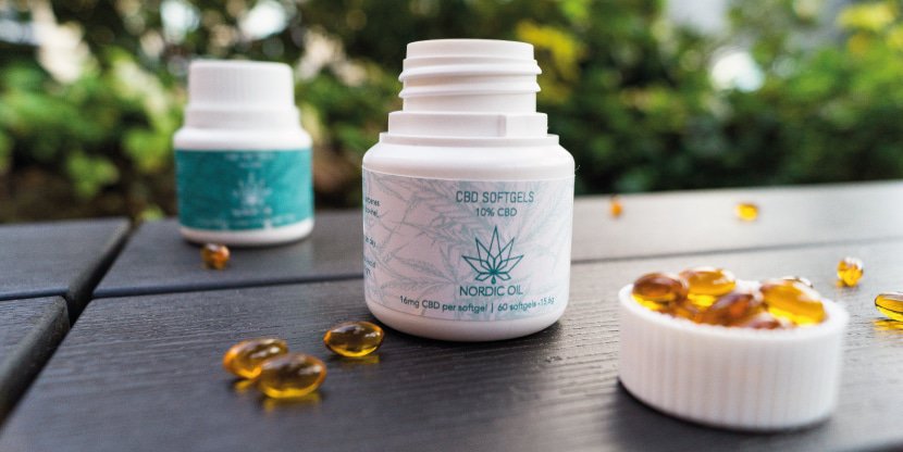Mit Öl gefüllte CBD Kapseln auf einem Tisch
